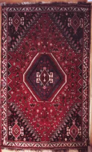 A woollen Qashqai rug from Iran with red, blue and cream geometric patterning