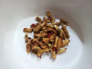 Several pale brown flattened jujube seeds on a dark surface