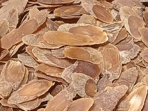A heap of thin, dried, golden-brown ginseng root slices