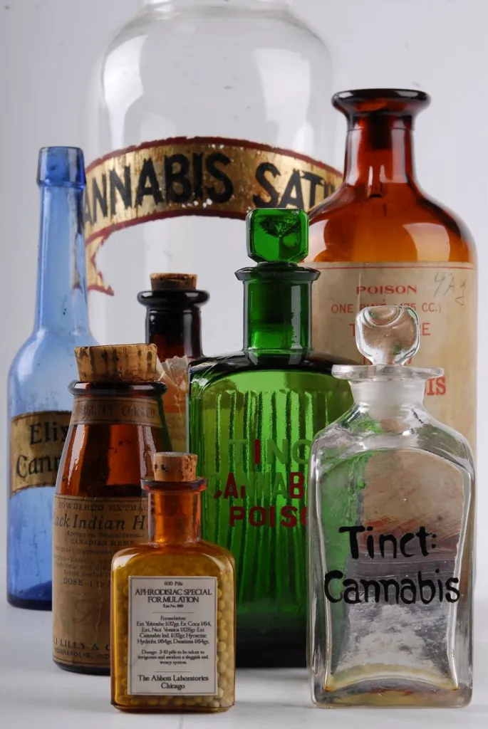 Antique glass medicine bottles of cannabis tincture and extract with old paper labels in a museum case
