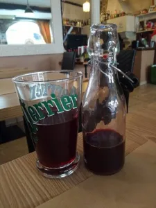 Bottle and glass of artisanal bissap juice made from Hibiscus sabdariffa in a restaurant