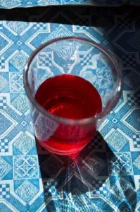 Glass of bright red karkade, the Hibiscus sabdariffa drink of Egypt and Sudan