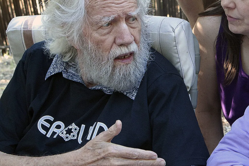Alexander Sasha Shulgin, white-bearded, talking in a garden chair at the Farm in Lafayette, California, 2009