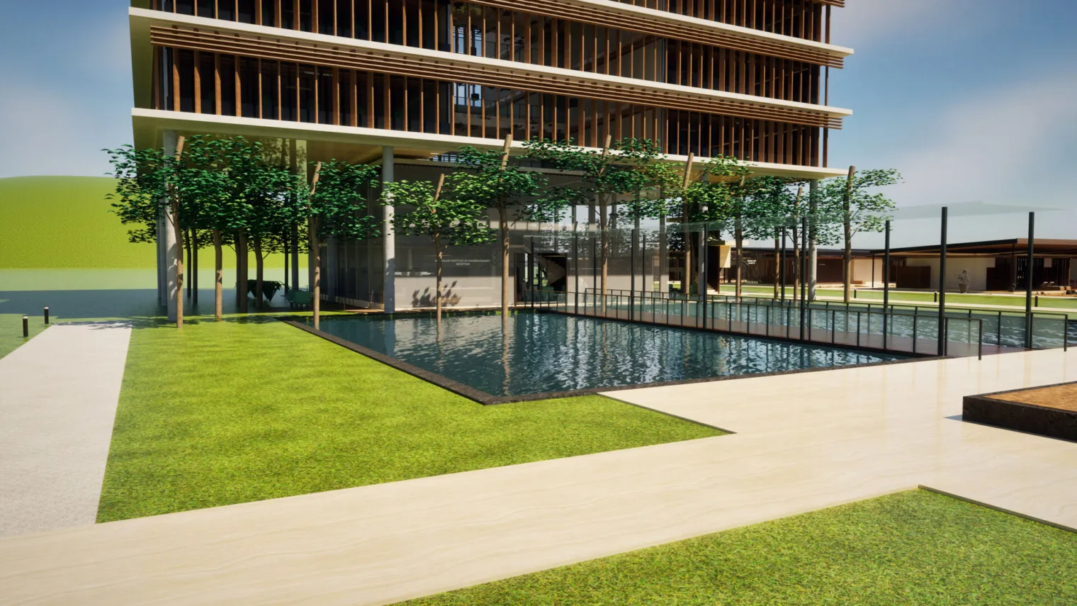 The Institute building in the Digital Campus: timber and glass levels above a reflecting pool, with a paved path and lawn in the foreground