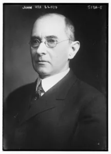 Black and white photograph of John Uri Lloyd in a dark suit and round spectacles