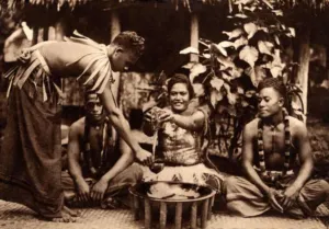 Samoan kava ceremony with a woman and two men seated behind a wooden tanoa bowl, early twentieth century