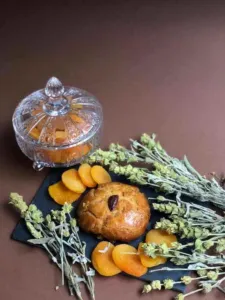 Bunches of dried mountain tea beside Albanian sheqerpare pastries and dried apricots